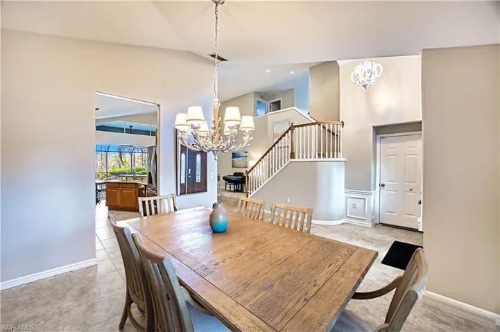 Kitchen featuring lofted ceiling, light stone countertops, decorative light fixtures, and a healthy amount of sunlight