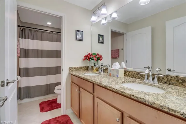 Bathroom featuring tile patterned floors, curtained shower, vanity, and toilet