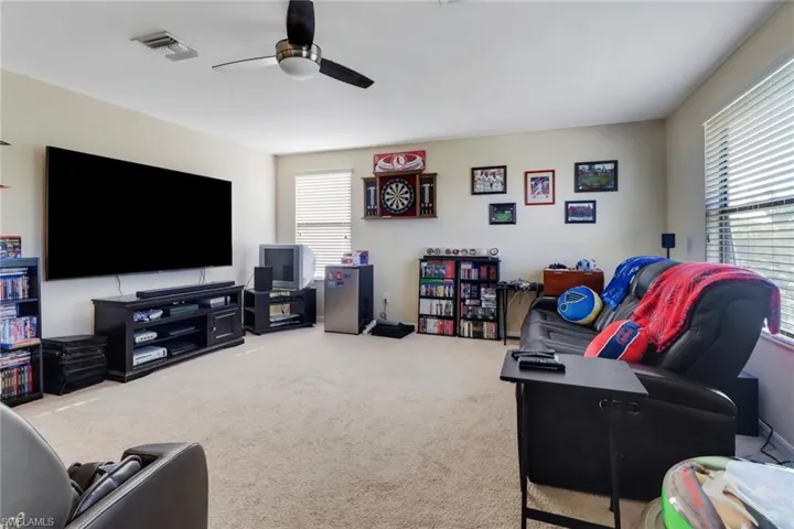 Carpeted living room with ceiling fan