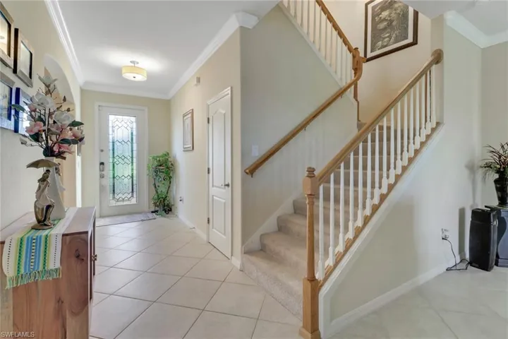 Foyer with ornamental molding and light tile patterned floors