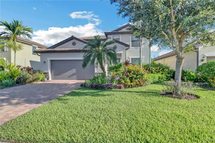 Mediterranean / spanish home with a garage and a front lawn
