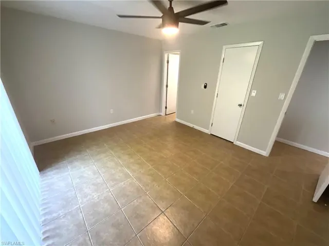 Unfurnished bedroom featuring ceiling fan and tile patterned flooring