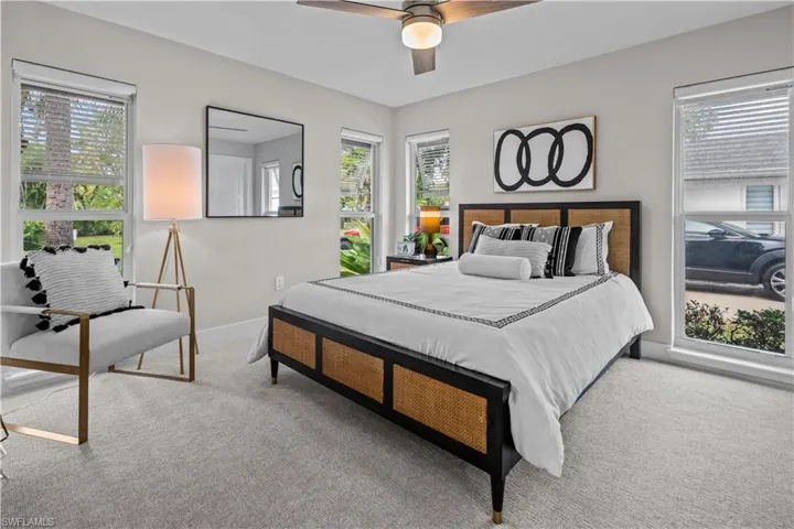 Bedroom featuring multiple windows, carpet flooring, and ceiling fan