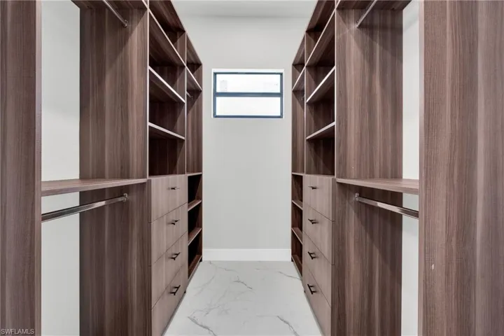 Spacious closet featuring marble finish floor