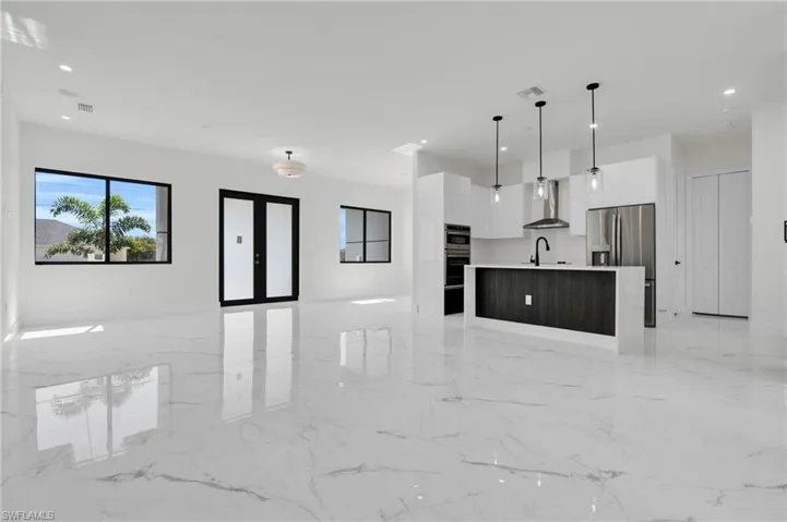 Unfurnished living room featuring visible vents, a sink, marble finish floor, and recessed lighting