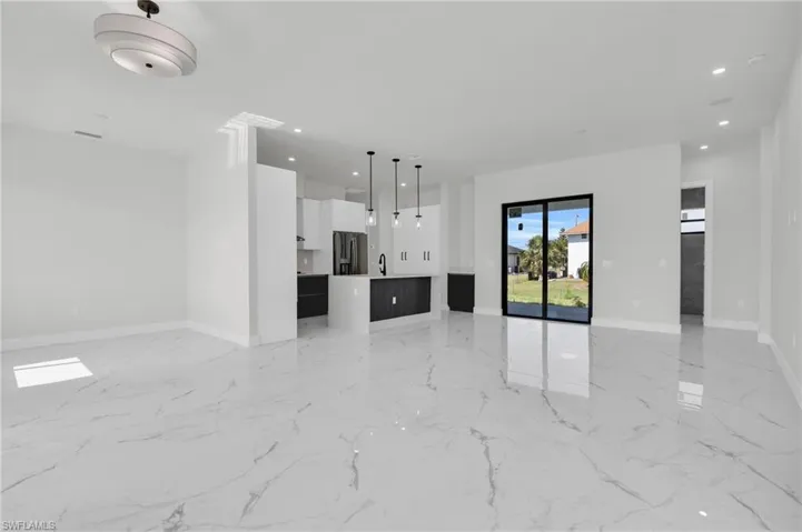 Unfurnished living room with a sink, baseboards, recessed lighting, and marble finish floor