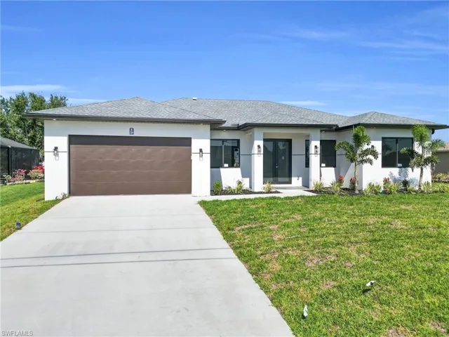 Prairie-style home featuring concrete driveway, an attached garage, a front yard, and stucco siding