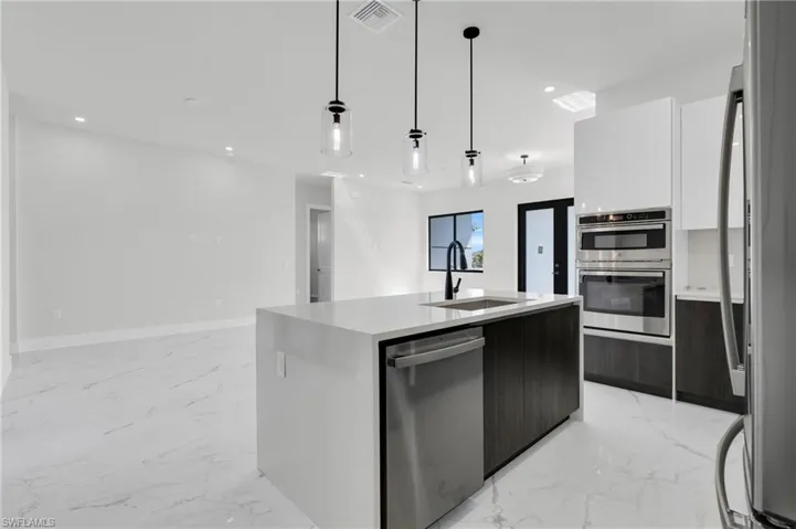 Kitchen featuring appliances with stainless steel finishes, a sink, and modern cabinets