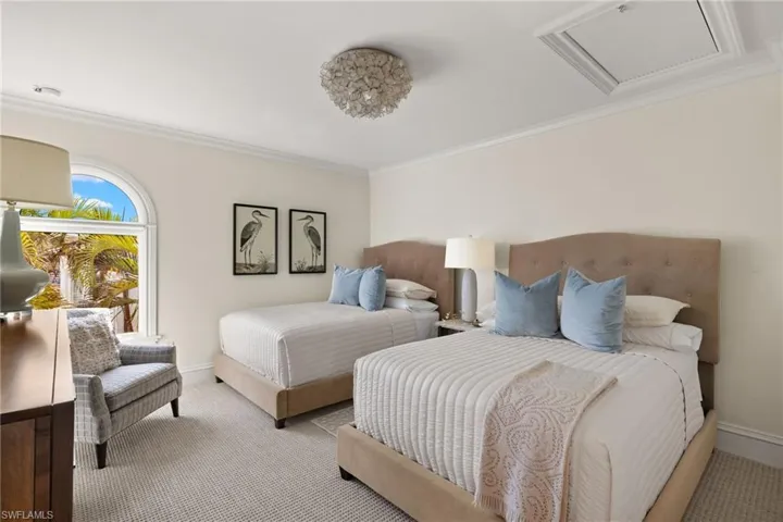 Bedroom with light carpet, ornamental molding, and baseboards
