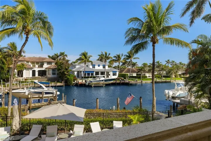 View of water feature featuring a residential view, a boat dock, boat lift, and fence