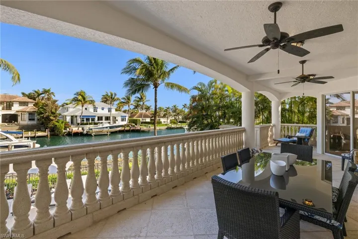 Balcony featuring a ceiling fan, a sunroom, and a water view