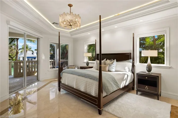 Bedroom featuring visible vents, baseboards, access to outside, ornamental molding, and a raised ceiling