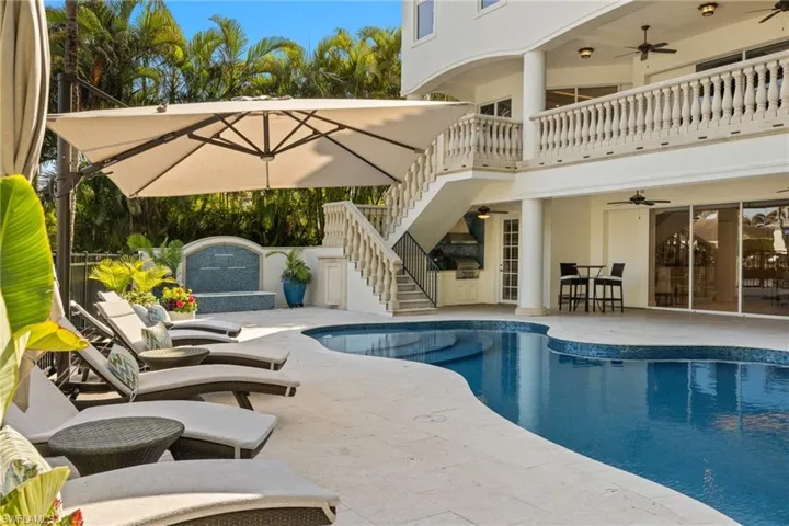 Pool with a patio area, ceiling fan, and stairway