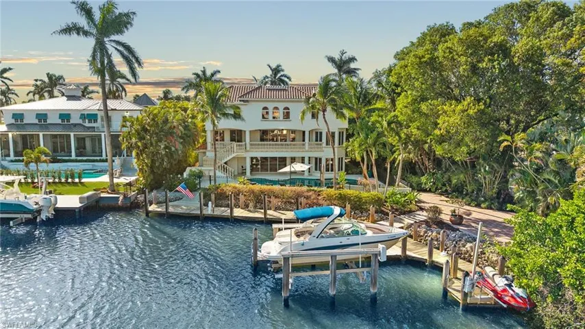 View of dock with a water view, boat lift, and an outdoor pool