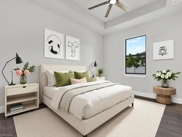 Bedroom featuring a tray ceiling, dark wood-type flooring, and ceiling fan