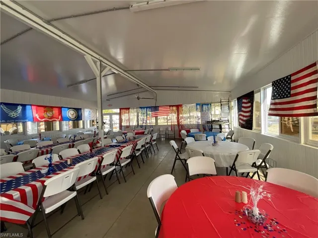 Dining area with lofted ceiling, rail lighting, concrete flooring, and wood walls