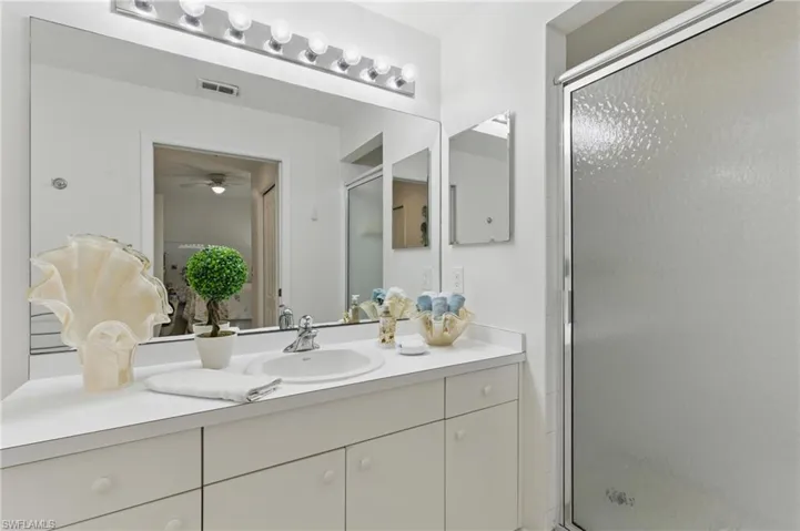 Bathroom with a ceiling fan, visible vents, a stall shower, and vanity