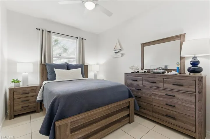 Bedroom with light tile patterned floors and ceiling fan