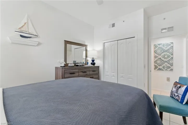Tiled bedroom with a ceiling fan, a closet, and visible vents