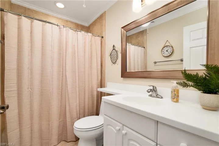 Full bath featuring vanity, curtained shower, crown molding, and recessed lighting