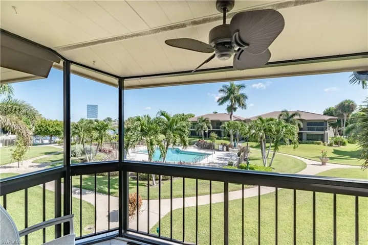 Balcony with view of pool area and ceiling fan