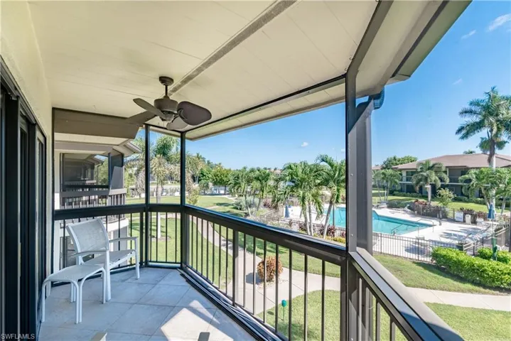 Balcony featuring view of pool area, a sunroom, and ceiling fan