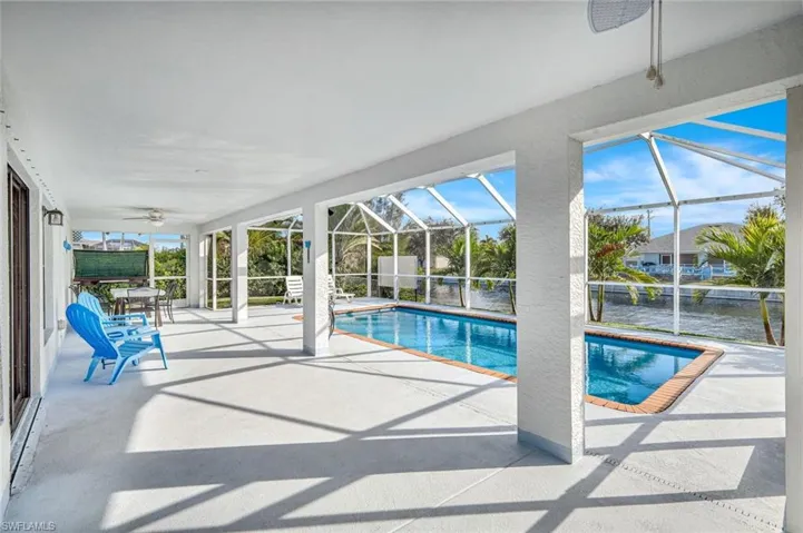 Outdoor pool with a sunroom, a patio area, and a lanai