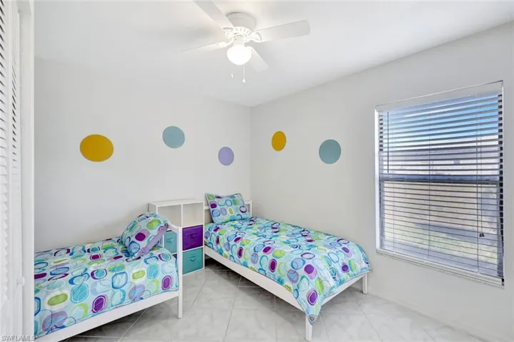 Bedroom with a ceiling fan and light tile patterned flooring