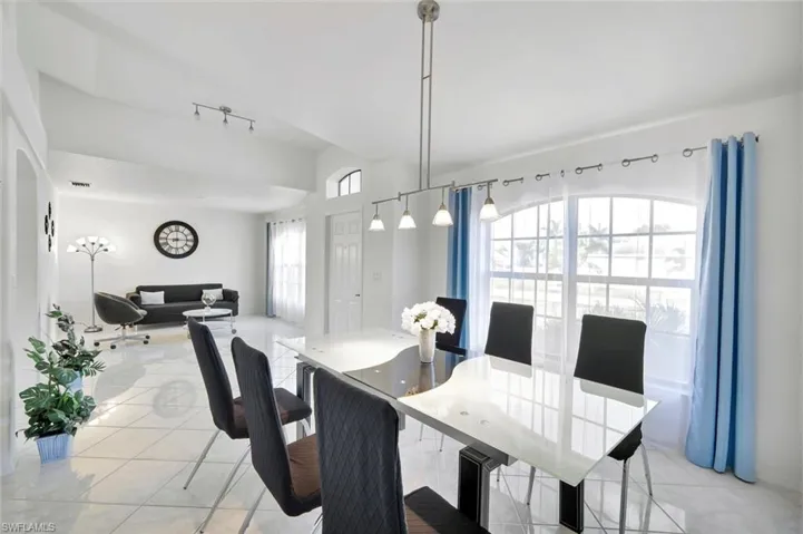 Dining area featuring rail lighting and light tile patterned floors