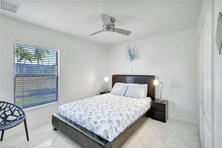 Bedroom with a ceiling fan and light tile patterned floors
