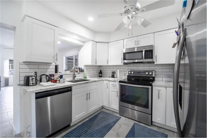 Kitchen featuring white cabinets, sink, and appliances with stainless steel finishes