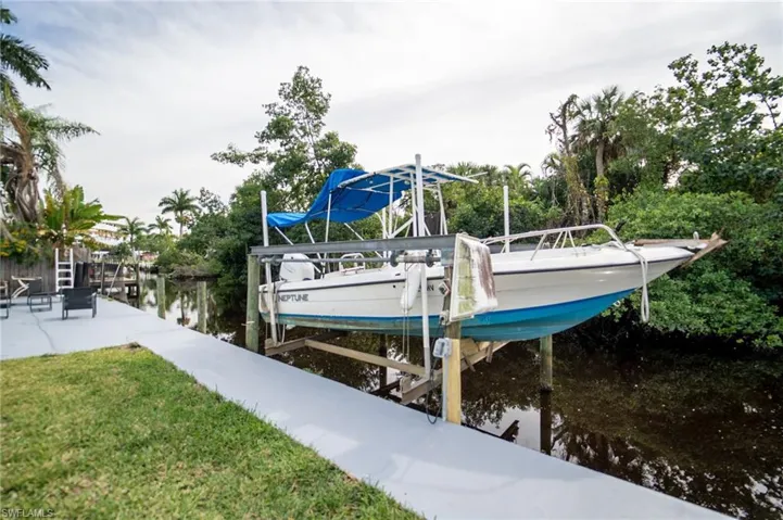 Dock area with a lawn and a water view