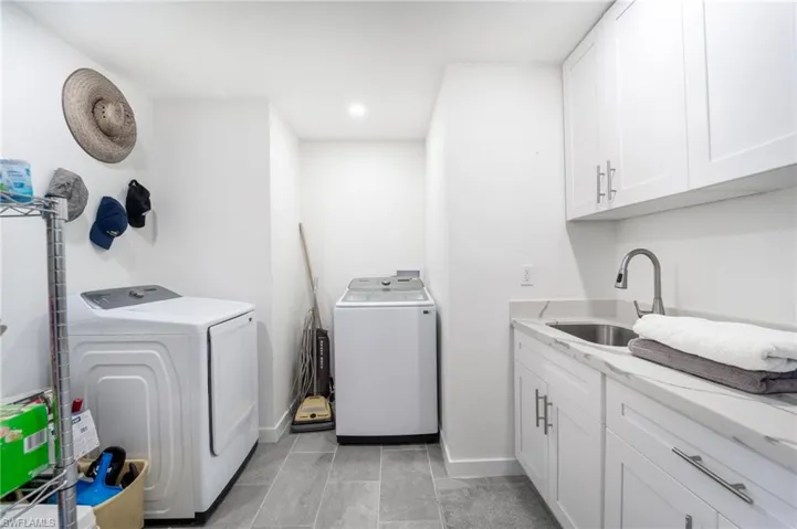 Laundry area featuring sink, cabinets, and independent washer and dryer