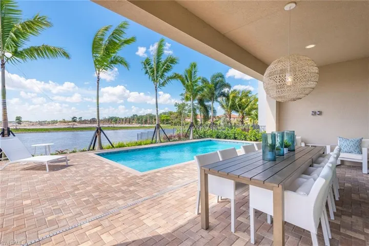 View of pool with a water view and a patio