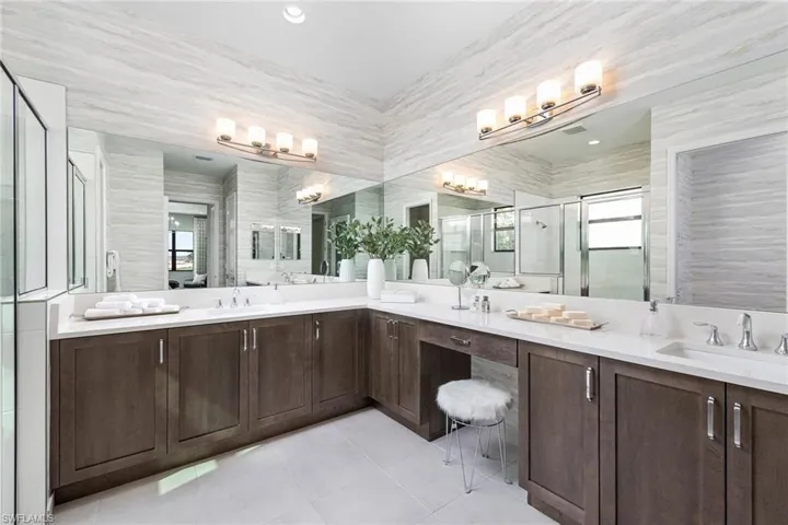 Bathroom with vanity, an enclosed shower, tile patterned floors, and tile walls