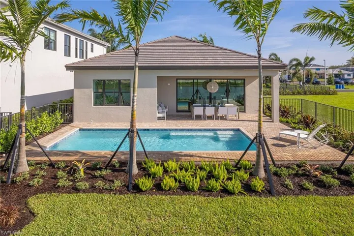 View of pool with a patio area and a lawn