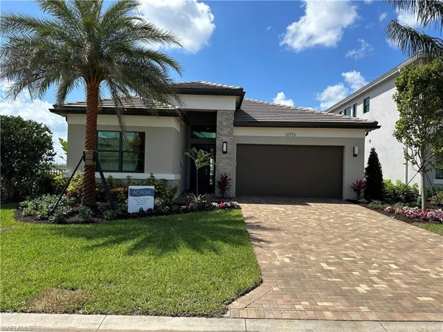View of front facade featuring a garage and a front lawn
