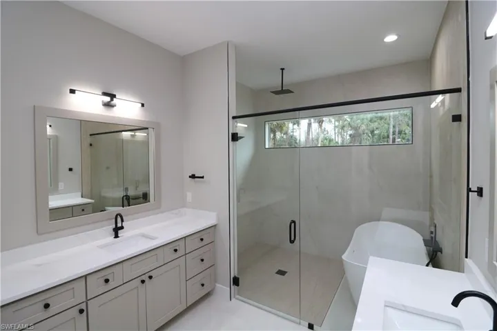 Bathroom with plus walk in shower, tile patterned flooring, and vanity