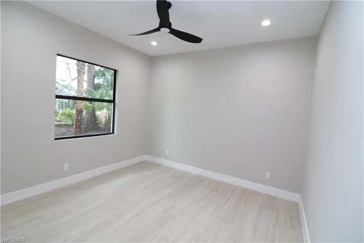Empty room with ceiling fan and light hardwood / wood-style floors