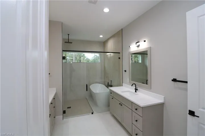 Bathroom featuring vanity and separate shower and tub