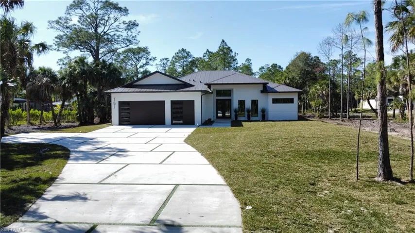 View of front of house featuring a garage and a front lawn
