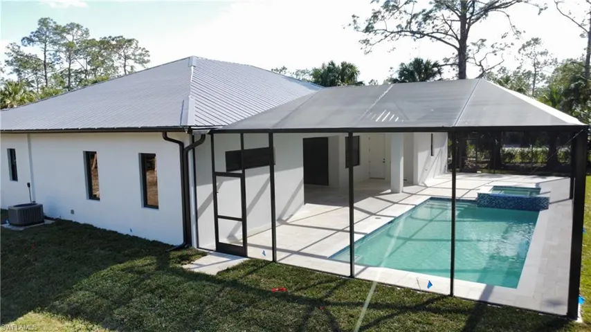 Rear view of house with cooling unit, a yard, and a patio