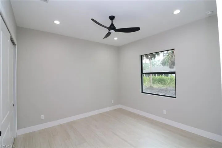 Empty room with ceiling fan and light hardwood / wood-style floors