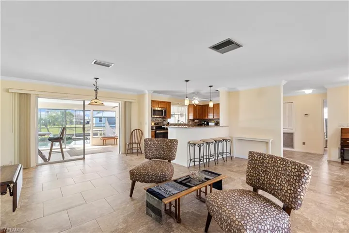 Living room with crown molding and light tile patterned floors