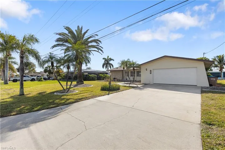 View of front of property featuring a garage and a front lawn