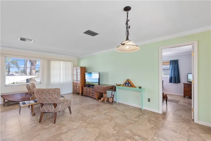 Sitting room with a wealth of natural light and ornamental molding