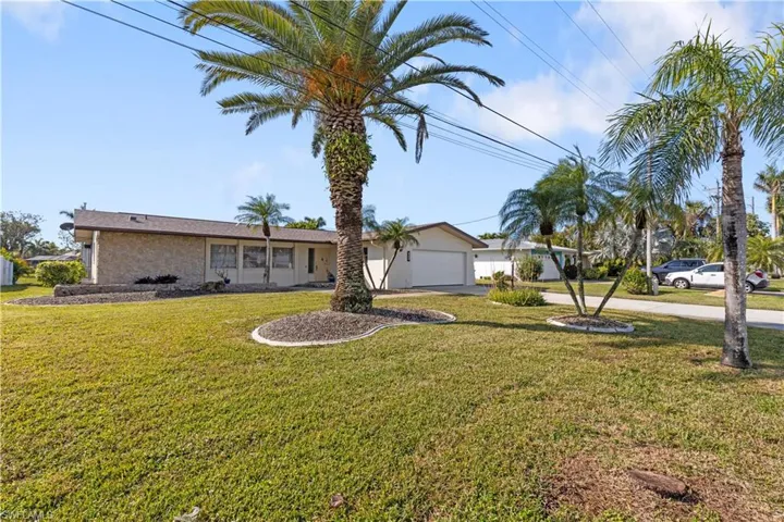 View of front of house with a garage and a front lawn