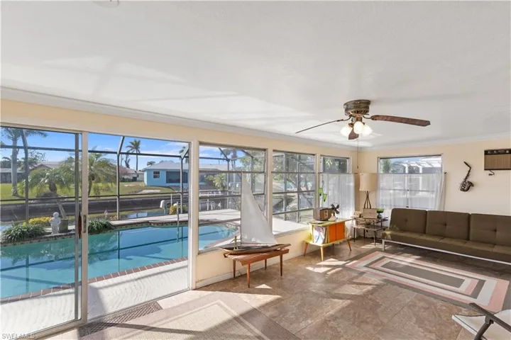 Sunroom featuring plenty of natural light, an AC wall unit, and ceiling fan