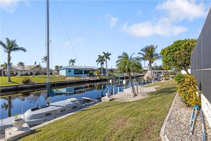 Dock area with a water view, a yard, and a lanai