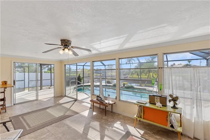 Sunroom / solarium with a wealth of natural light and ceiling fan